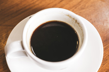 Top view image of hot coffee cup on vintage wooden table in cafe