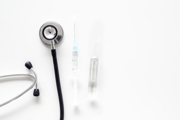 Infuenza vaccine in syringe near stethoscope on white background top view copy space