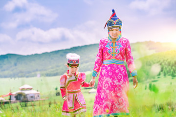 Obraz premium Mother and daughter wearing Mongolian costumes on the grassland