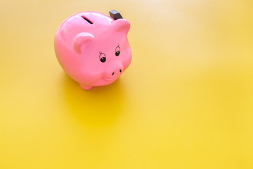 Piggy bank. Moneybox in shape of pig near hammer on yellow background copy space