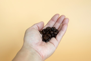 roasted coffee beans on the palm of one's hand