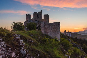 Rocca Calascio (Italy) - The ruins of an old medieval village with castle and church, over 1400 meters above sea level on the Apennine mountains in the heart of Abruzzo, at sunset.
