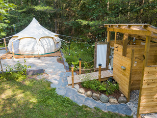 Aerial drone shot of a glamping tent in a forest