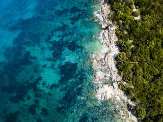 Aerial view of an amazing rocky and green coast bathed by a transparent and turquoise sea. Sardinia, Italy.