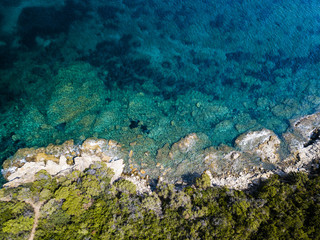 Aerial view of an amazing rocky and green coast bathed by a transparent and turquoise sea. Sardinia, Italy.