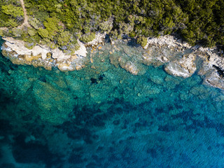 Aerial view of an amazing rocky and green coast bathed by a transparent and turquoise sea. Sardinia, Italy.