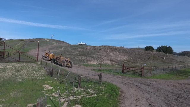 towed scraper hauling mud behind a D5 bulldozer in the green hills
