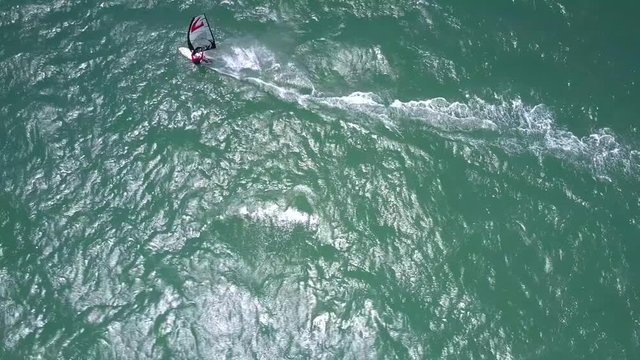 windsurfer fights with wind and ocean waves