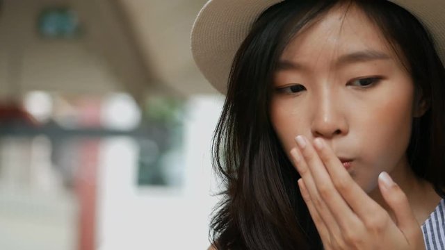 Young asian woman eating strawberries in cafe her very delicious. Close up her face.