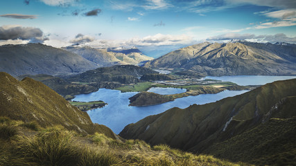Wide mountain landscape with lake, hills and blue sky in Wanaka New Zealand on Roys Peak