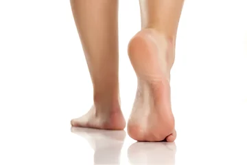 Fotobehang vrouwelijke blote voeten op witte achtergrond © vladimirfloyd