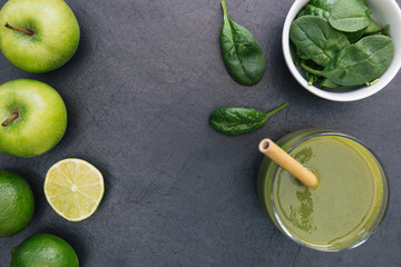 Green smoothie drink with straw on dark background copy space