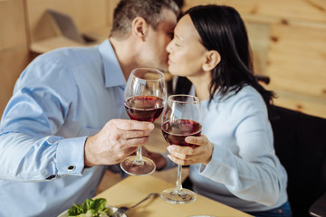 Great evening. High-spirited cheerful man and woman resting while drinking wine in a restaurant
