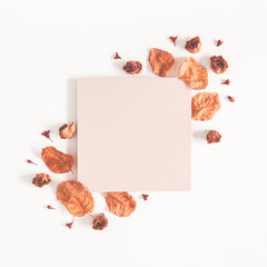 Autumn composition. Paper blank, dried flowers and leaves on white background. Autumn, fall concept. Flat lay, top view, copy space, square