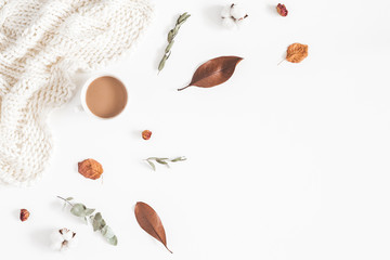 Autumn or winter composition. Cup of coffee, dried autumn leaves, knitted blanket on white background. Flat lay, top view