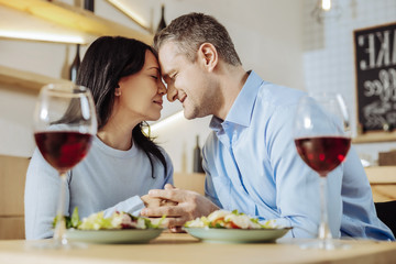 Happy relations. Tender brunette woman spending time with a man while drinking wine