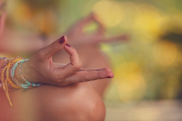 Young woman practicing yoga - meditation in the tropical garden.