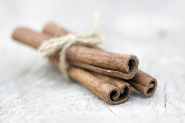 Fresh raw cinnamon sticks on wooden table, sticks tied with one jute natural twines