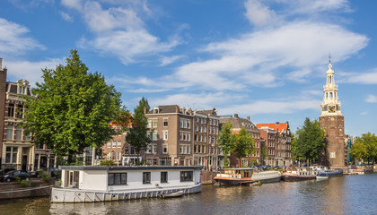 Fototapeta na wymiar Historical tower Montelbaanstoren and houseboats in Amsterdam, Netherlands