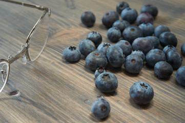 Blueberries and glasses on old wood background