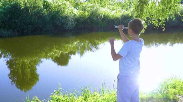 Thoughtful watchful serious young boy wants to see something in distance outside. Kid holds vintage grey spyglass in hands and looks through it. Real time 4k video footage.