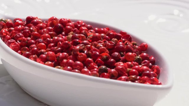 Dry spices pink pepper on a rotary table. 4K. Macroshooting.