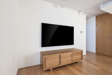 television with wood shelf in a white interior.