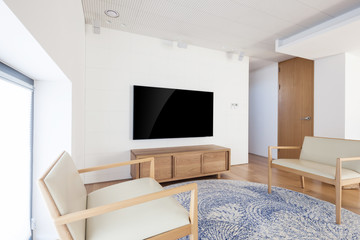 television with wood chair in a white interior