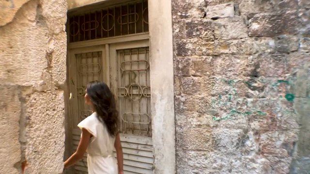 Beautiful smiling young girl walking narrow old streets of Splt old town and Diocletian palace, Split, Dalmatia, Croatia