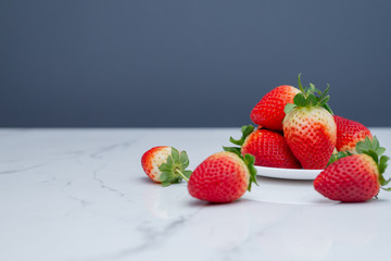 Fresh strawberries in ceramic plate on Modern white background.