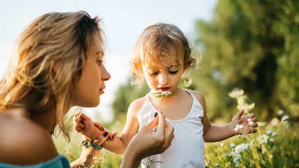 Fototapeta premium mother giving flowers to daughter in field