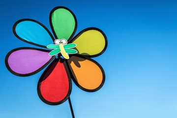 children's windmill in the garden against the blue sky