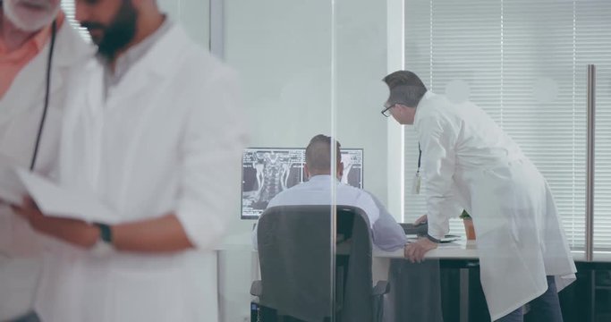 Doctors scientists examine cancer patients. Doctors oncologists look at MRI pictures on computer and reading documents. Research cancer center