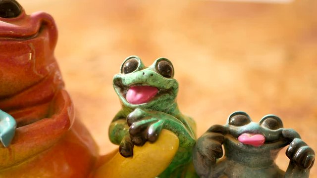 Cute green frog figurine making funny face.