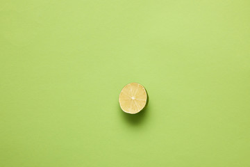 top view of halved ripe lime on light green background