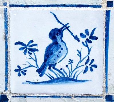 Traditional portuguese tiles azulejo, tiny blue bird, Blue and white azulejos on the building's exterior in Lisbon, Portugal.