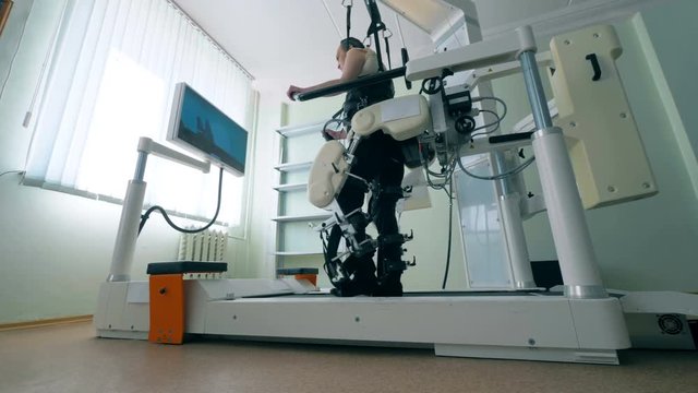 A man walks with the help of a prosthetic device at a modernc clinic. 4K.