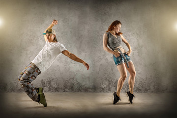 Fototapeta na wymiar Hip Hop dancer in dynamic action jump on the grunge grey