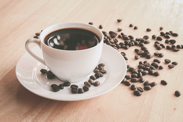 Coffee cup and coffee beans on wooden table