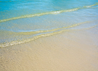 Fototapeta na wymiar Light reflection on the surface of movement sea on sand beach