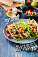 Authentic mexican tacos with chicken and salsa with avocado, tomatoes and chillies