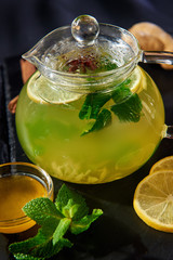 transparent glass teapot with citric tea and a saucer of honey