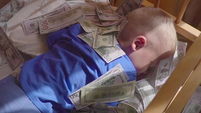 sleeping baby and falling money. Concept unexpected wealth.
