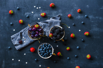 Berries mix  - blueberries, blackberries, cherries and strawberries -in baskets, top view flat lay