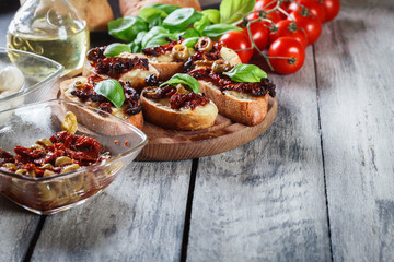 Appetizer bruschetta with sun-dried tomatoes, olives and mozarella.