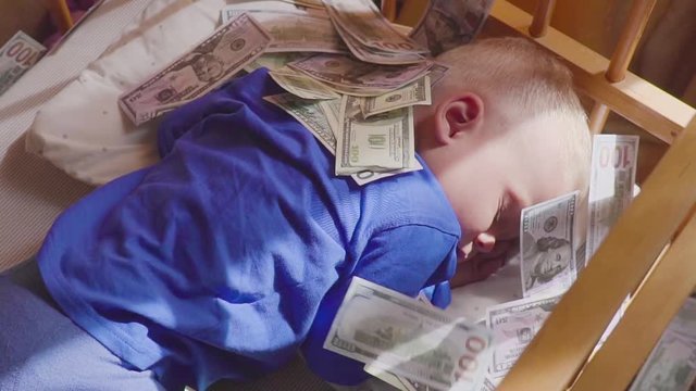 sleeping baby and falling money. Concept unexpected wealth.