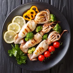  Grilled squid with fresh vegetables close-up on a plate. top view © FomaA
