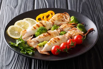 Plexiglas foto achterwand Healthy snack: grilled squid with tomatoes, broccoli, lemon and pepper closeup on a plate. horizontal © FomaA
