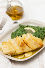 fried cod fish with spinach on dish