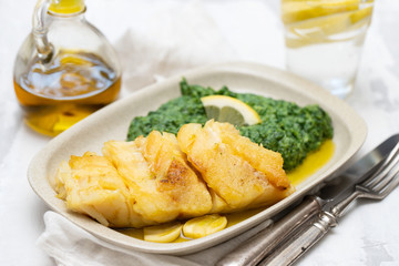 fried cod fish with spinach on dish